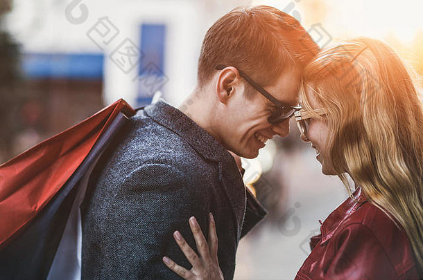一对年轻夫妇在城里购物的照片。城市里一对带着购物袋的夫妇的肖像。<strong>人</strong>、销售、爱情和幸福的概念。