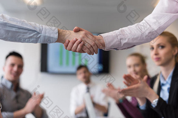 在现代创业公司<strong>商务办公</strong>室内部，女企业家在团队会议上与一群人握手的<strong>场景</strong>模糊不清