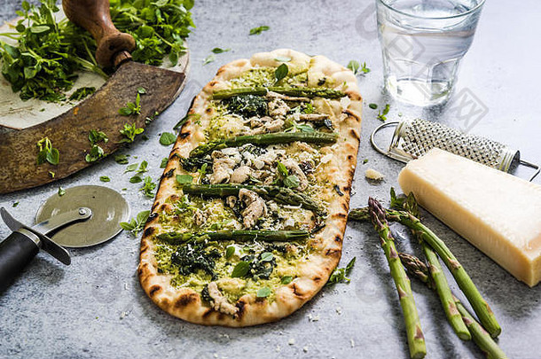 披萨配上新鲜的春季蔬菜和香草，从头顶的石板背景上