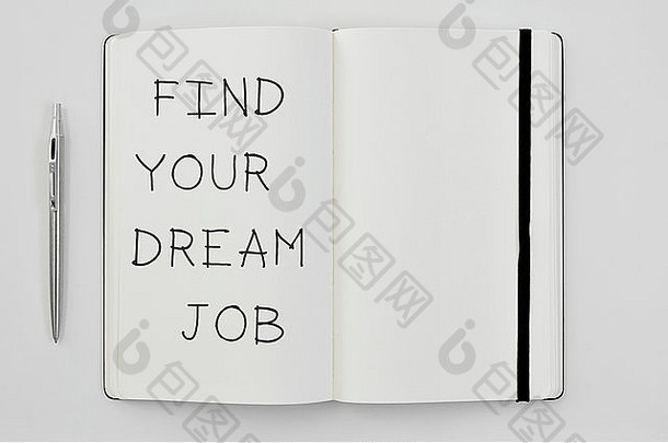 一支笔和一个记事本的高角度照片，上面写着“找到你梦想的工作”