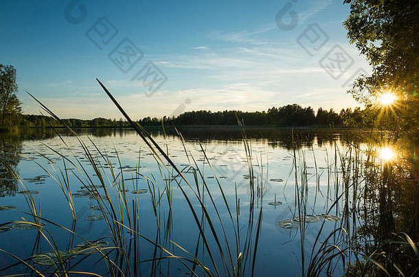 瑞典湖边的日落。美丽的自然和风景图片温暖的夏夜。平静<strong>祥和</strong>的画面。快乐的宁静。