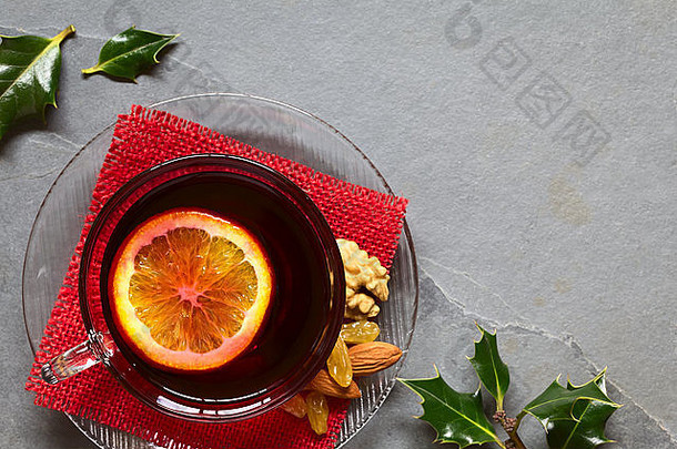 加香料的热红色的酒橙色片前玻璃杯冬青叶子一边