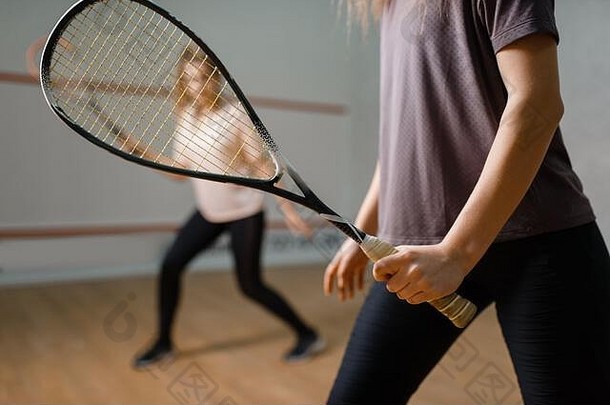 两名女选手用球拍、壁球比赛