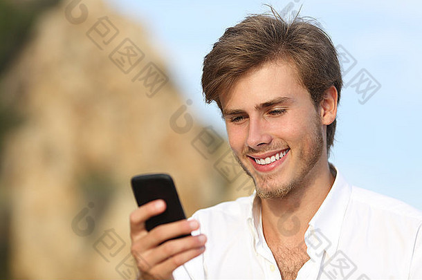英俊的年轻人在户外用手机，背景是天空