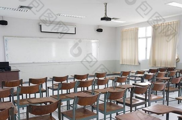 空荡荡的教室里有很多椅子，没有学生。空荡荡的教室里摆放着老式木椅。回到学校的概念。