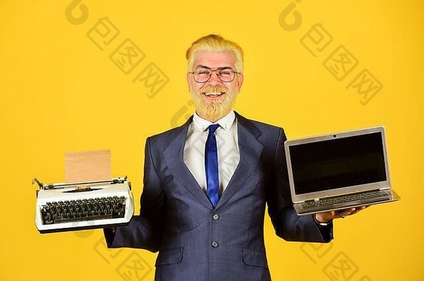 <strong>在线</strong>工作。老式打字机。成功的商人使用复古打字机和现代笔记本电脑。成熟的男人染胡须。电脑或打字机。新老技术。现代数字商务。