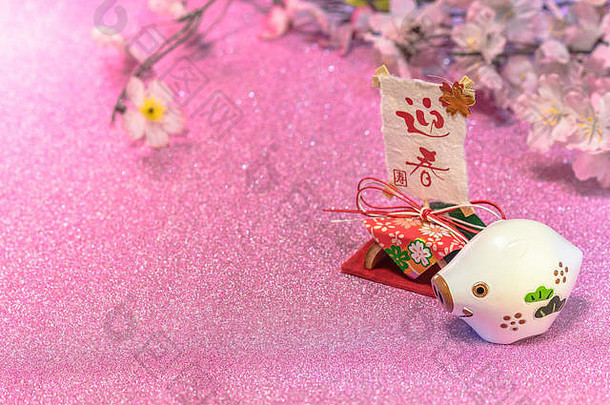 日本新年贺卡的亮丽背景，印有可爱的猪或猪的动物雕像和印有“给顺”字样的宣纸