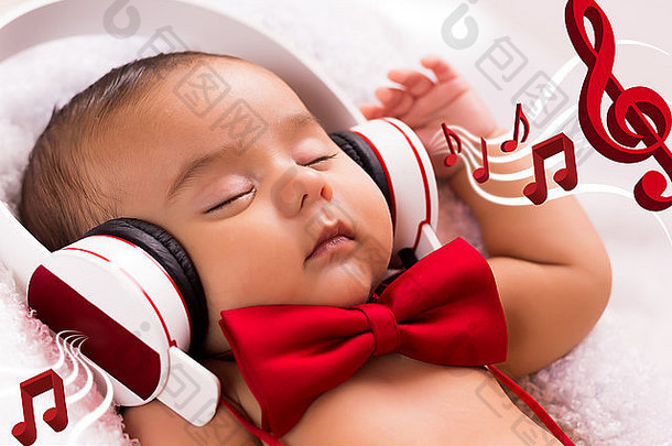 两个月大的漂亮宝宝戴着耳机，戴着复古红领带，轻松地听着音乐