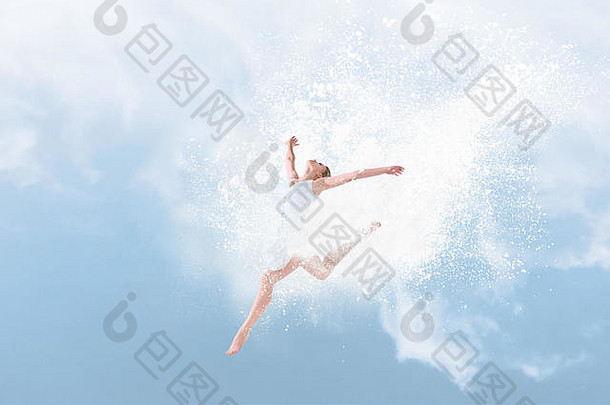 美丽的芭蕾舞演员在蓝天前的粉末云中跳跃
