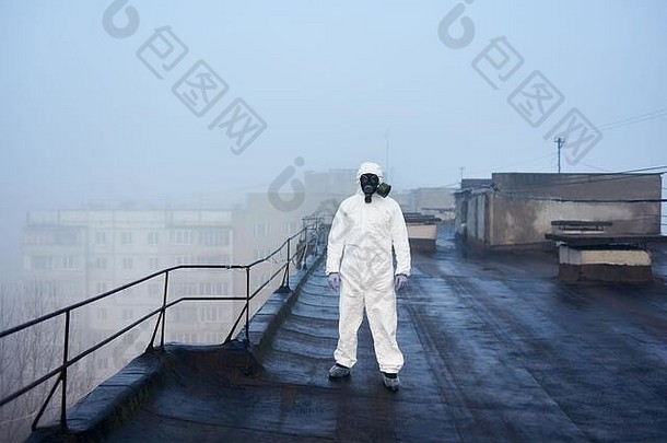人类站屋顶块公寓穿白色保护西装气体面具学习条件下未来研究