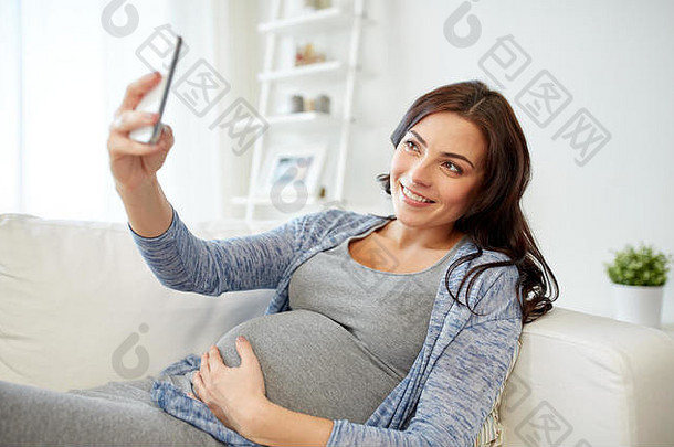 怀孕了女人采取智能手机自拍首页