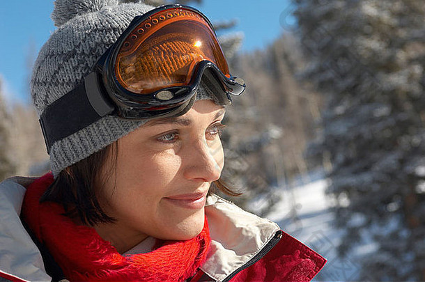 雪地里头戴滑雪镜的年轻女子，肖像。