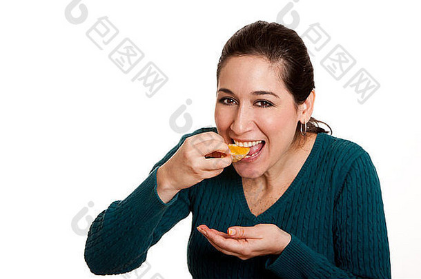 美丽快乐的女人吃一片富含维生素C的橘子汁，健康饮食。