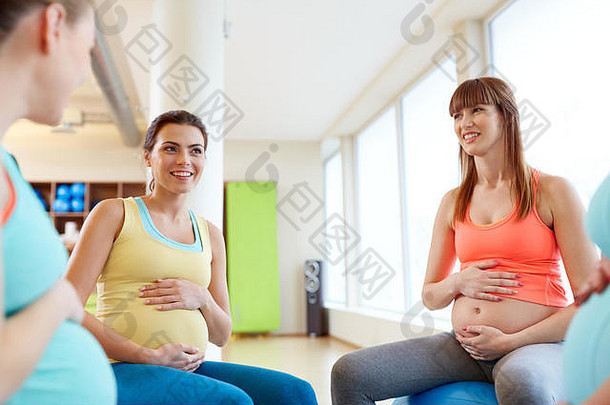 坐在健身房健身球上的孕妇