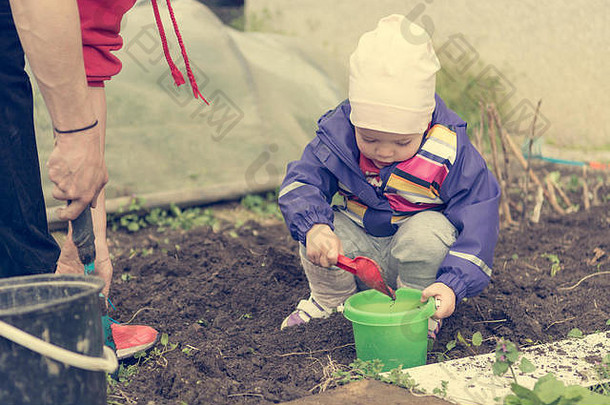 小女孩探索花园，帮助进行春季<strong>大扫除</strong>。