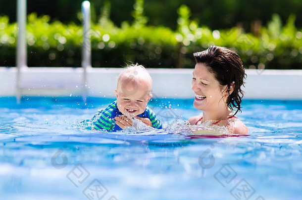 快乐年轻的妈妈。玩婴儿户外游泳池热夏天一天孩子们学习游泳家庭假期