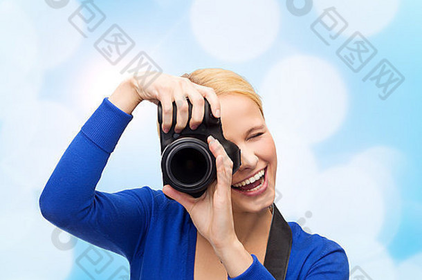 微笑的女人用数码相机拍照