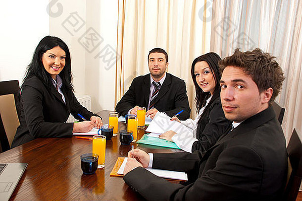 <strong>四</strong>位商务人士开会，坐在桌旁做文书工作