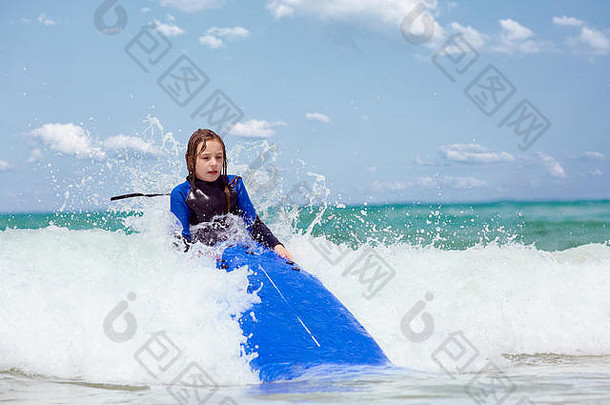 海浪拍打着拿着冲浪板的女孩