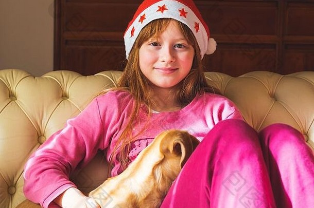 戴圣诞帽的红头发小女孩和她的小狗