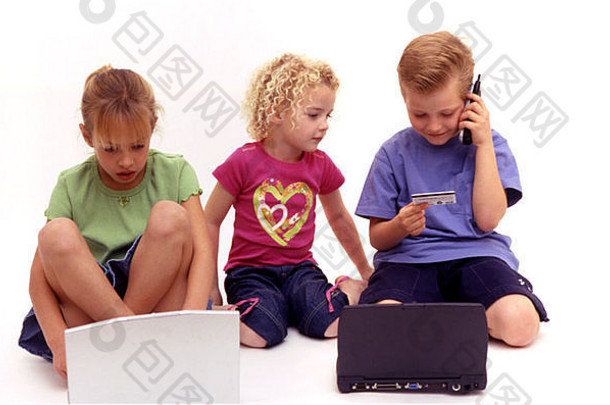 三个小孩玩笔记本电脑、手机和