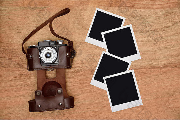 老式相机装在皮箱里，木制书桌上有四张空白照片