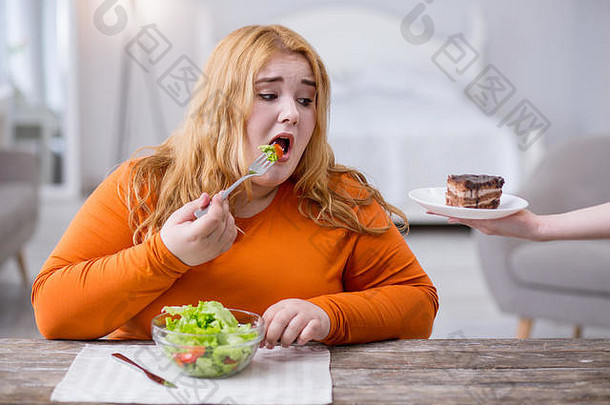 悲伤的胖女人吃健康的早餐