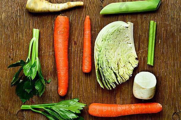 一些不同的生蔬菜，如胡<strong>萝卜</strong>、防风草、<strong>萝卜</strong>、卷心菜和芹菜的高角度拍摄，拍摄于一个乡村