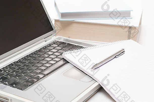 白色背景上带记事本和笔的办公桌笔记本电脑
