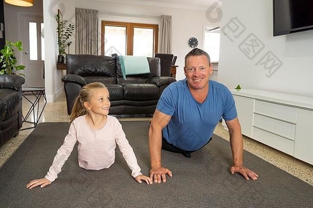 2019冠状病毒疾病关闭。快乐的父亲和女儿在隔离期间一起锻炼。一家人在室内做体育活动很开心。呆在家里