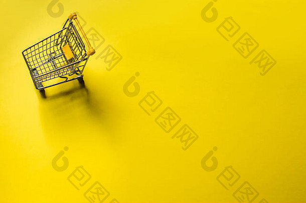 黄色背景的小推车。网上购物概念