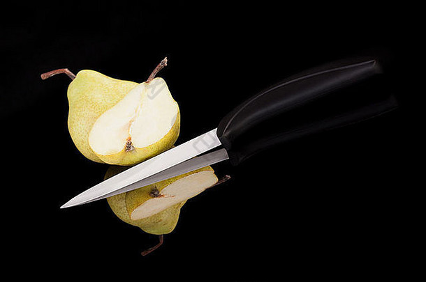 梨陶瓷刀孤立的黑色的背景豪华的健康的水果概念