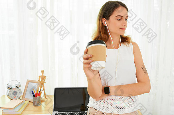 女人耳机喝咖啡