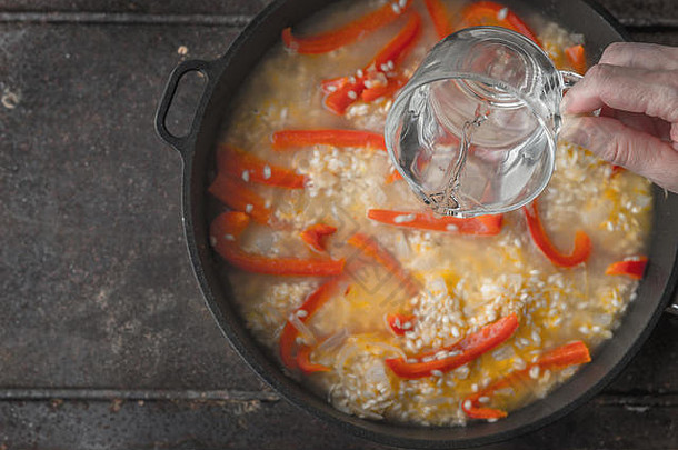 在平底锅中加水，加入大米和甜椒，俯视图