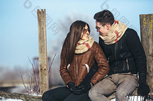 坐在旧篱笆上的年轻夫妇