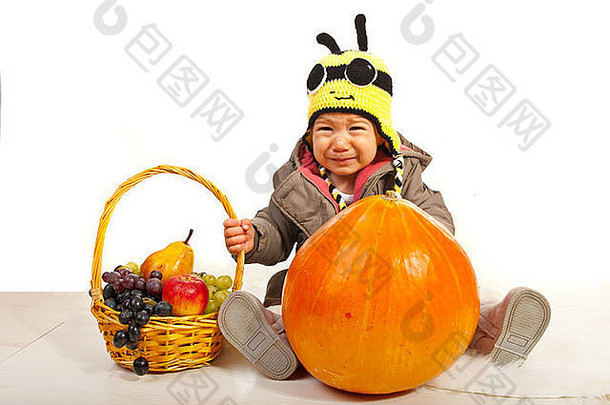 悲伤的秋天男孩抱着篮子，篮子里的葡萄被隔离在白色的背景上