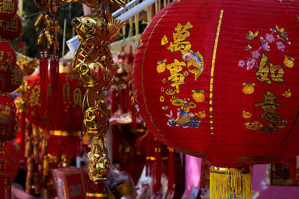 中国新年红纸灯笼的传统装饰，带有金色象形文字和金鱼特写