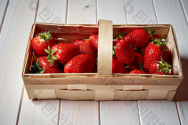 新鲜的多汁的红色的草莓篮子白色表格