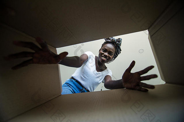 年轻的非洲女人开放纸箱盒子搬迁拆包概念