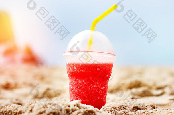 在海滩上用塑料杯盛放新鲜西瓜，在户外喝新鲜饮料