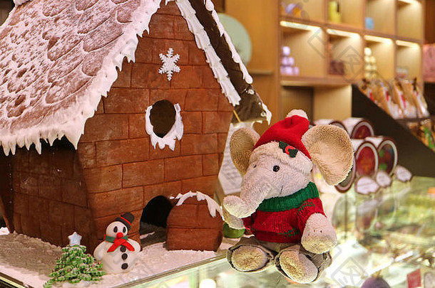 圣诞装饰品上有穿着圣诞老人服装的可爱大象软玩具和姜饼屋前的杏仁糖雪人