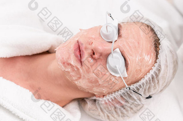 一位年轻女病人的画像。专业设备抗痤疮光疗。照片复原过程中的美女。美容诊所的面部皮<strong>肤</strong>治疗。