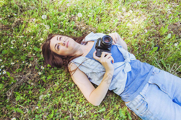 年轻的女人业余摄影师放松自然古董相机