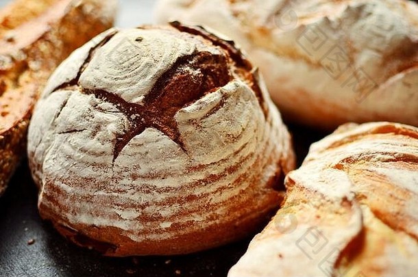 放在柳条篮中的烘焙产品。圆面包、带种子的长面包、不含酵母的纯<strong>素面</strong>包。木质背景