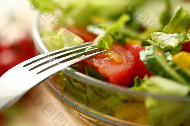 盘子里的银叉混合沙拉和新鲜蔬菜