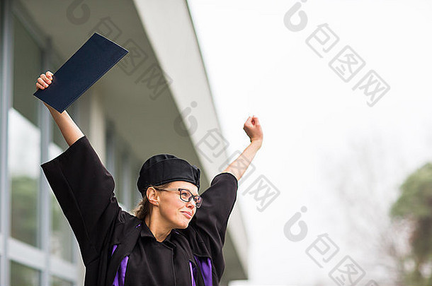 美丽的年轻女子欢庆她的毕业典礼-检查她的文凭，对她获得的头衔感到高兴/印象深刻（科罗拉多州）
