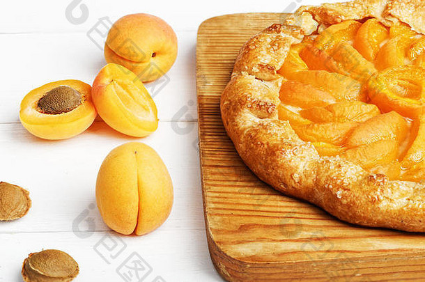 白色木桌上放着的桃子和鲜黄桃子饼干馅饼。