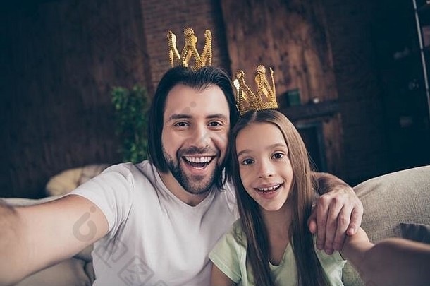 小搞笑女士的特写照片她英俊的爸爸友谊坐在舒适的沙发上自拍拥抱戴金色王冠名人成名