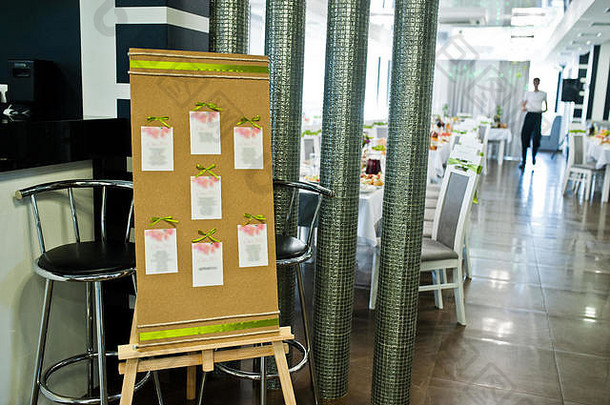 餐厅里的婚礼客人用绿色丝带装饰板。