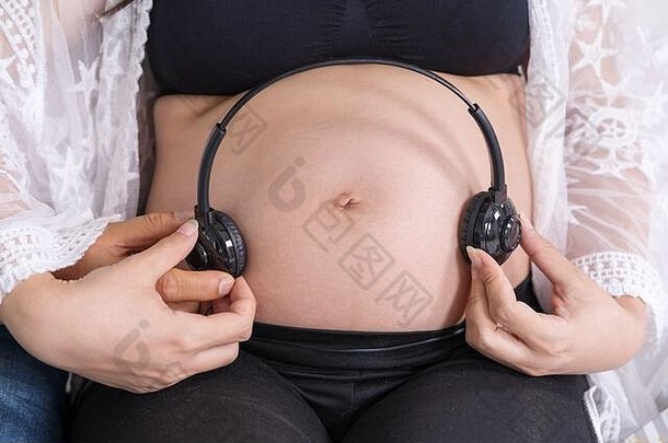 关闭怀孕了女人丈夫玩音乐婴儿耳机肚子